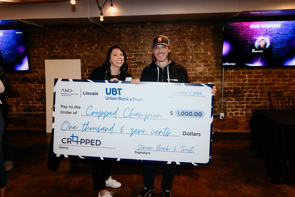 Man and woman holding large check for $1,000